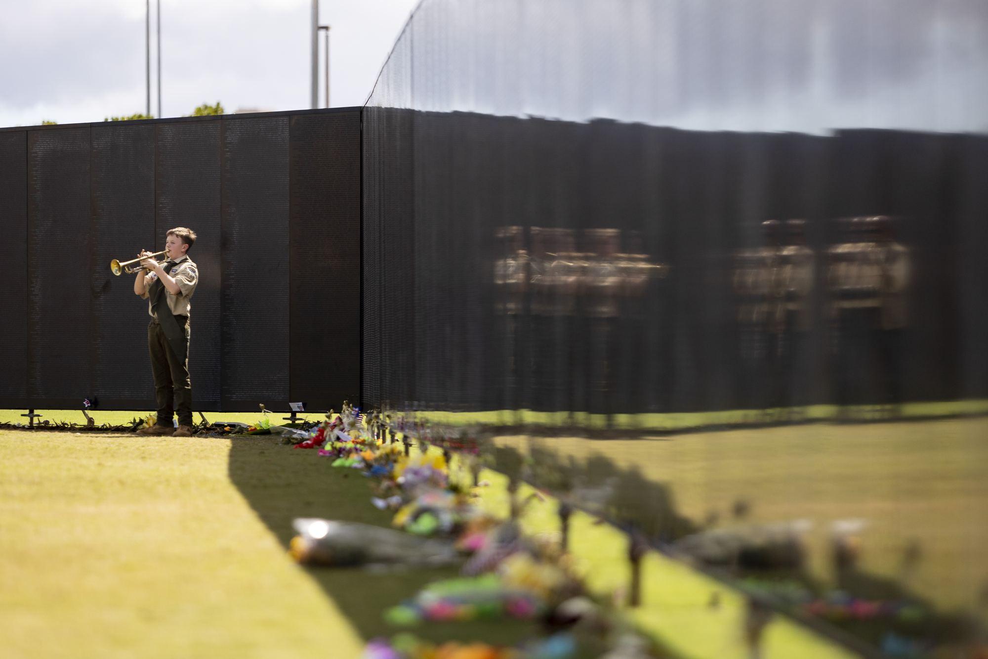 A scout sounds Taps at the apex of The Wall That Heals